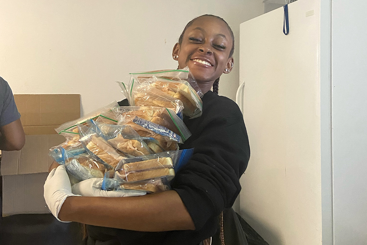 Jordine Jones holds an armful of the sandwiches she helped prepare to distribute to people living on the streets in Atlanta. Jones was so moved when she participated in the Sandwich Run with local nonprofit Lifting Our Voices that she cofounded a chapter at Georgia Tech. (Photo Courtesy: Jordine Jones)
